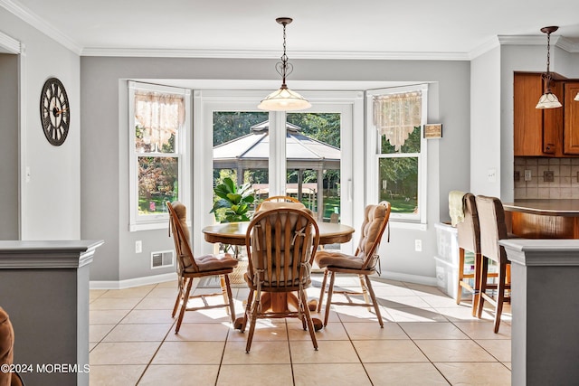 dining room featuring crown molding and light tile patterned floors