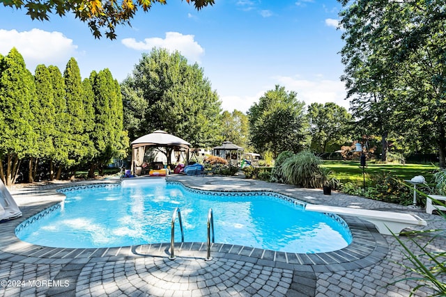 view of pool with a patio, a gazebo, and a diving board