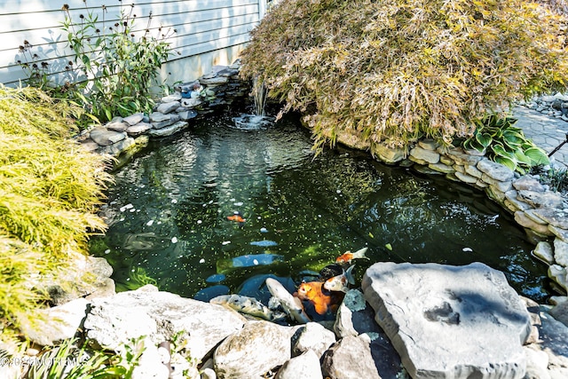 exterior details with a garden pond