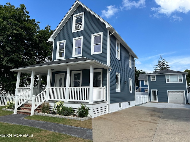 view of front of house featuring a porch, a garage, and an outdoor structure