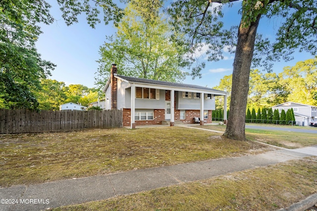 bi-level home featuring a porch and a front lawn