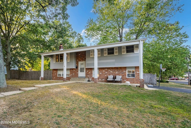 raised ranch featuring a front lawn