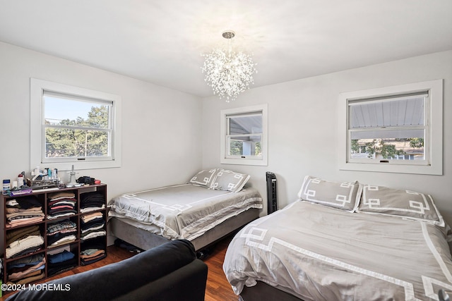 bedroom with wood-type flooring and a chandelier