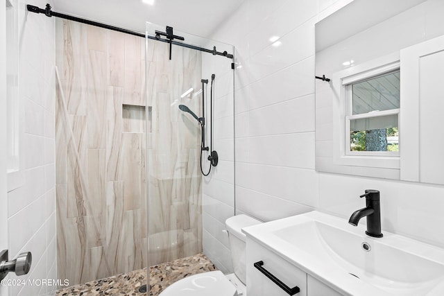 bathroom with tile walls, toilet, a tile shower, and vanity