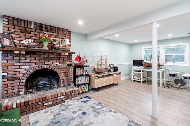 living room with ornate columns, a brick fireplace, beamed ceiling, and light hardwood / wood-style flooring