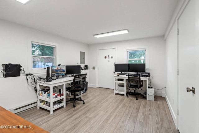 office area featuring baseboard heating, light hardwood / wood-style flooring, and electric panel