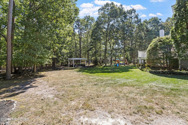 view of yard featuring a playground and a pergola