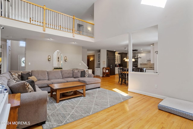 living room featuring light hardwood / wood-style floors and a high ceiling