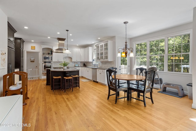 dining space featuring a chandelier, light hardwood / wood-style floors, and sink