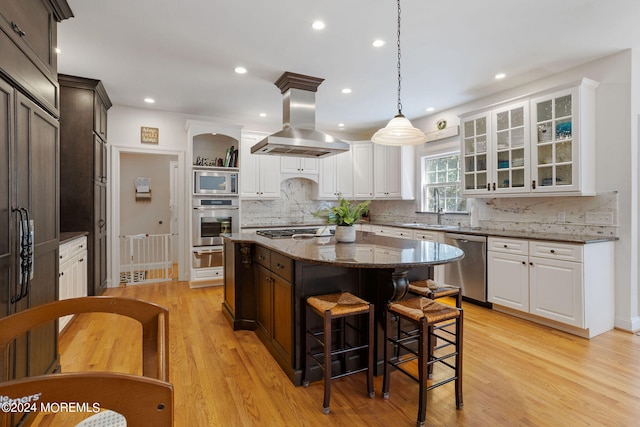 kitchen featuring a center island, sink, light hardwood / wood-style floors, island exhaust hood, and stainless steel appliances