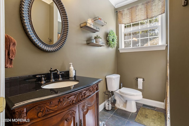 bathroom with tile patterned flooring, vanity, toilet, and ornamental molding