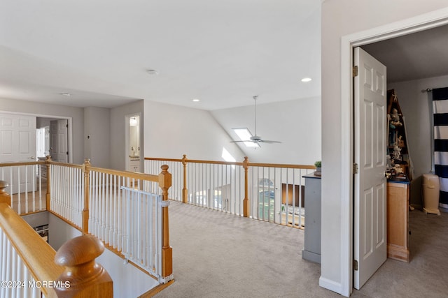 hall featuring light colored carpet and lofted ceiling