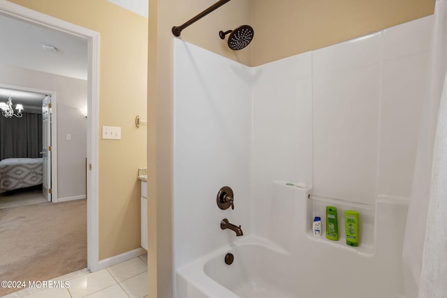 bathroom with tile patterned floors, vanity, washtub / shower combination, and a chandelier