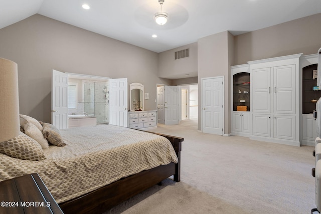 bedroom featuring light carpet, ceiling fan, ensuite bathroom, and high vaulted ceiling