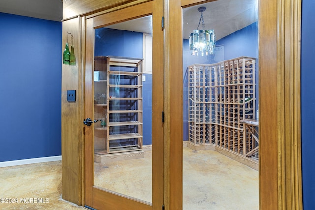 wine room with concrete flooring and an inviting chandelier