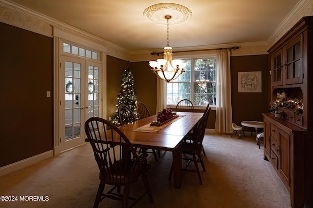 carpeted dining space featuring a chandelier, french doors, and ornamental molding