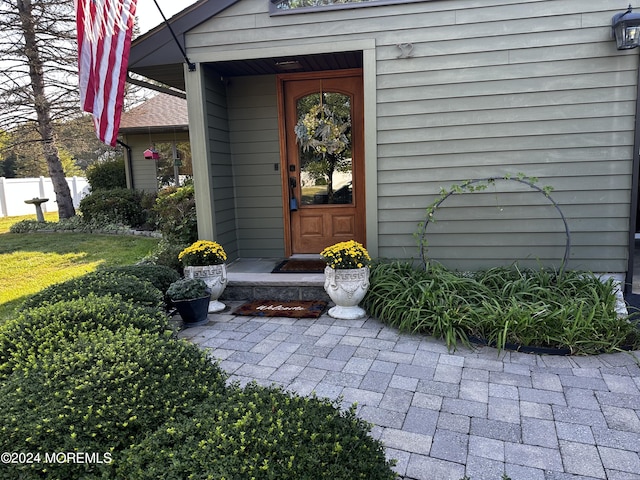 view of exterior entry featuring a lawn