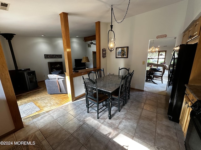 dining room with ceiling fan with notable chandelier and tile patterned flooring