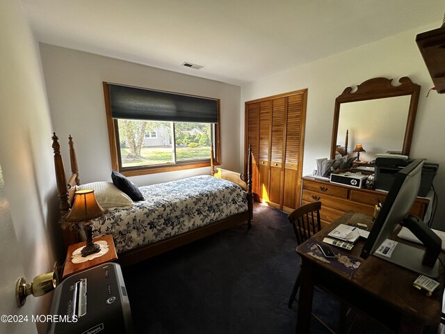 bedroom featuring dark carpet and a closet