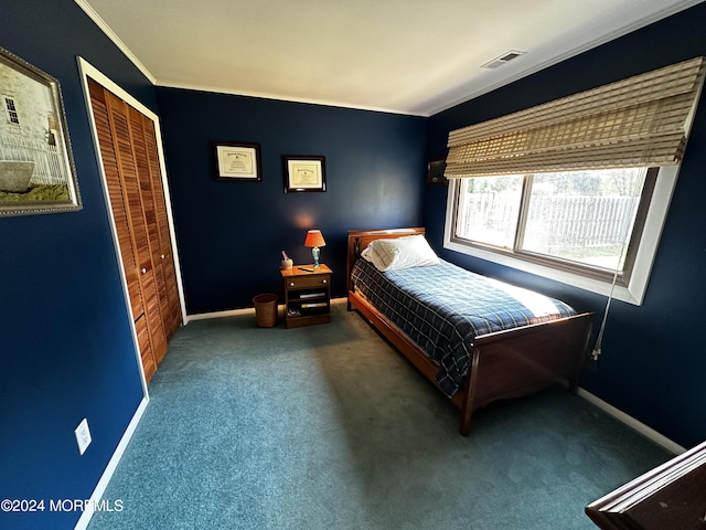 bedroom with a closet, crown molding, and dark colored carpet