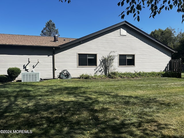 view of side of home with a yard and central AC unit