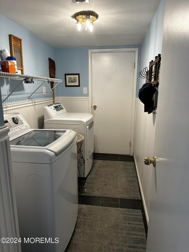 laundry area featuring dark tile patterned floors and washer and clothes dryer