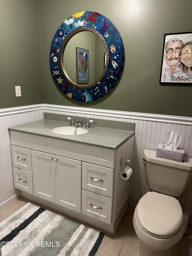 bathroom featuring vanity, tile patterned flooring, and toilet