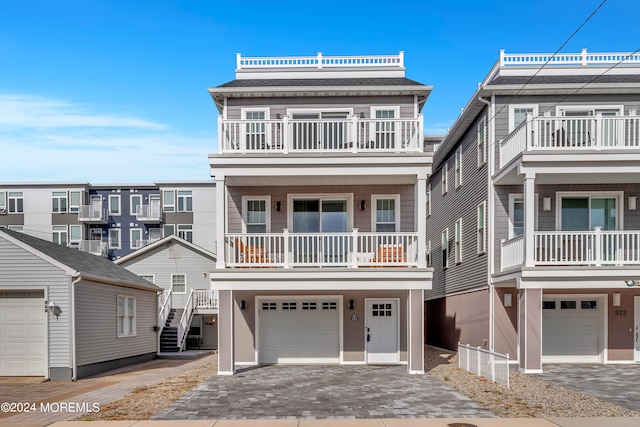 view of front of property featuring a balcony and a garage