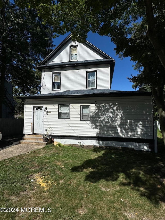 back of house featuring a lawn