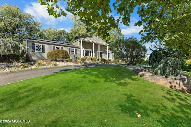 view of front of home with covered porch and a front lawn