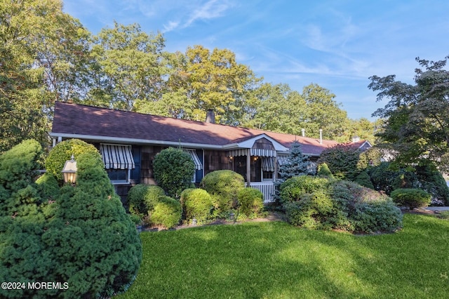 view of front facade featuring a sunroom and a front lawn