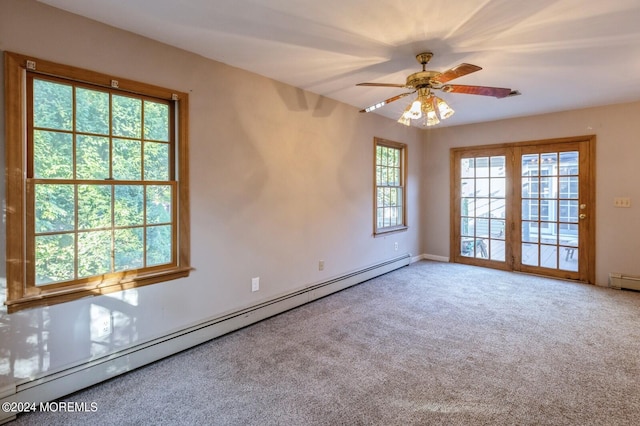 carpeted spare room with french doors, ceiling fan, a baseboard heating unit, and a healthy amount of sunlight