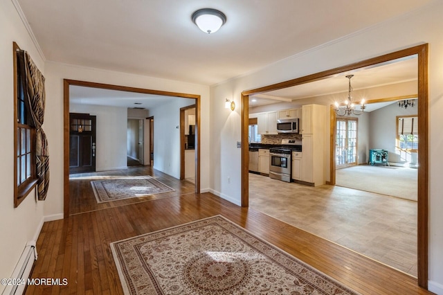 corridor with ornamental molding, hardwood / wood-style floors, an inviting chandelier, and a baseboard radiator