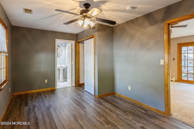 spare room with dark wood-type flooring, baseboard heating, sink, and ceiling fan