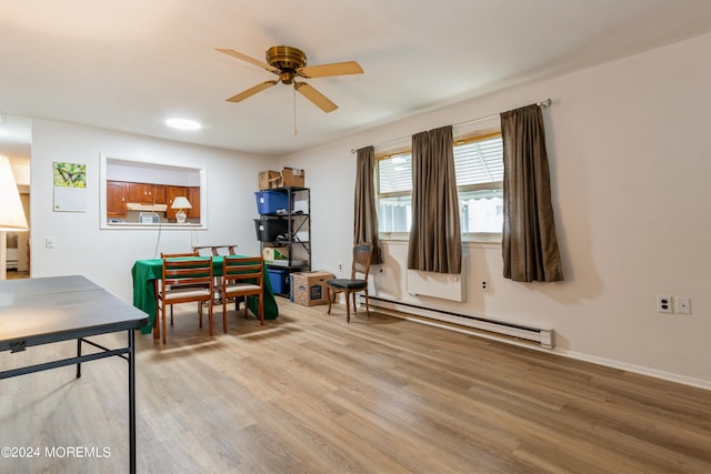 office area with ceiling fan, light wood-type flooring, and a baseboard heating unit