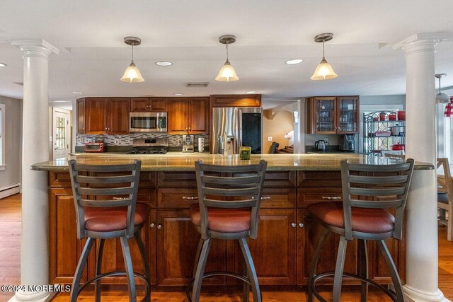 bar featuring appliances with stainless steel finishes, decorative backsplash, decorative columns, and dark hardwood / wood-style floors