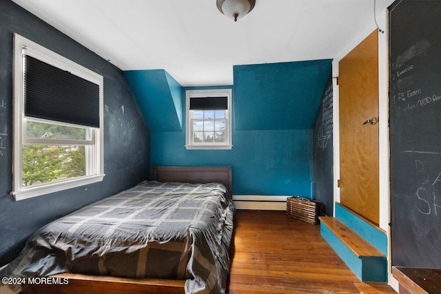 bedroom with lofted ceiling, baseboard heating, hardwood / wood-style floors, and multiple windows