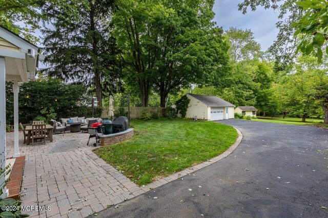 exterior space with an outbuilding, an outdoor living space, a garage, a patio area, and a front yard