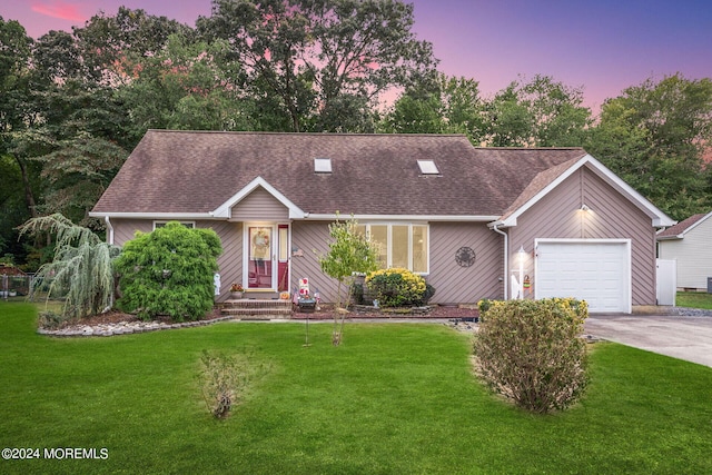 ranch-style home featuring a garage and a lawn