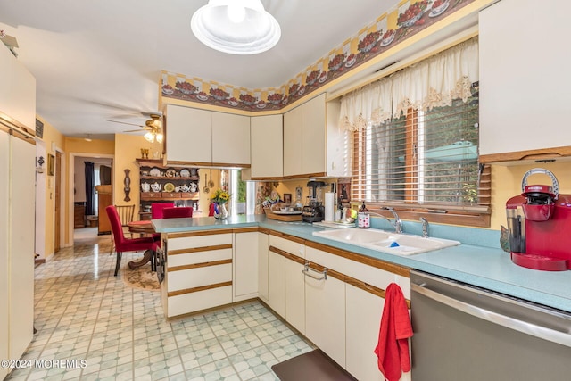 kitchen with kitchen peninsula, dishwasher, ceiling fan, and sink