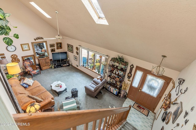 living room with ceiling fan, a skylight, carpet floors, and high vaulted ceiling