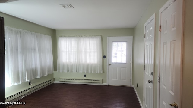 foyer entrance featuring dark wood-type flooring and a baseboard heating unit