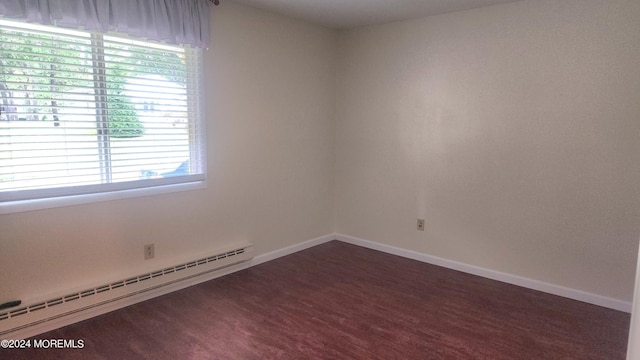 empty room with dark carpet and a baseboard radiator