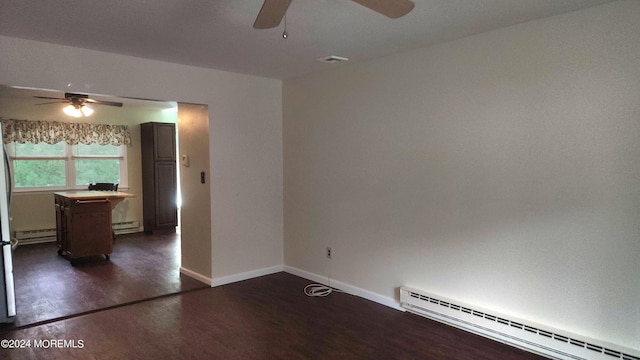 empty room featuring baseboard heating, ceiling fan, and dark hardwood / wood-style flooring