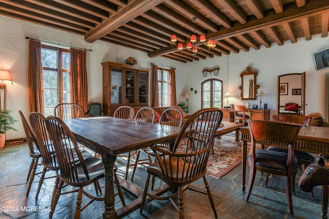 dining room with beam ceiling and a notable chandelier