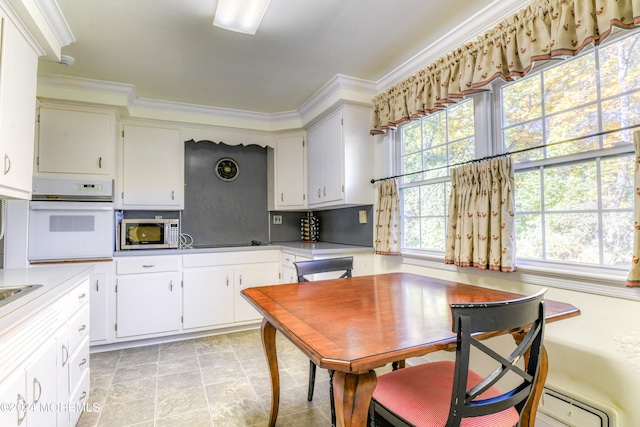 kitchen with crown molding, oven, white cabinets, and a baseboard radiator