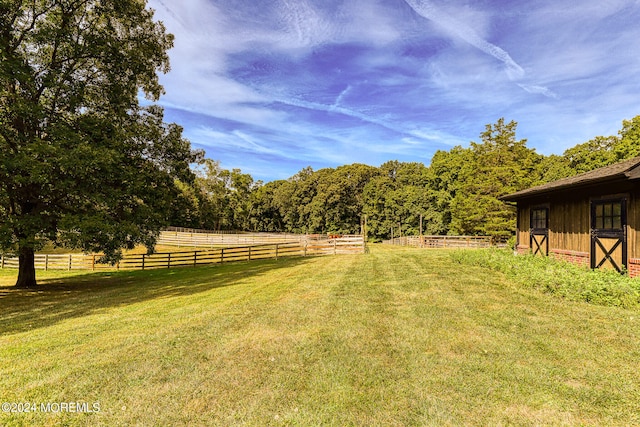 view of yard featuring an outdoor structure and a rural view