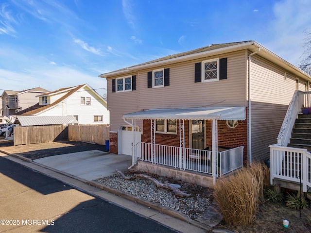 318 Bayview Ave, Union Beach, NJ 07735 - view of front facade with a garage, concrete driveway, fence, a porch, and brick siding