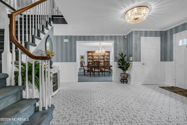 foyer entrance featuring an inviting chandelier and ornamental molding