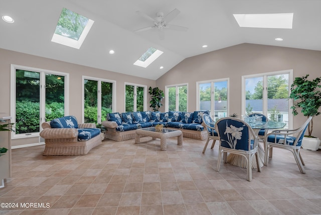 interior space featuring ceiling fan, vaulted ceiling with skylight, and a wealth of natural light